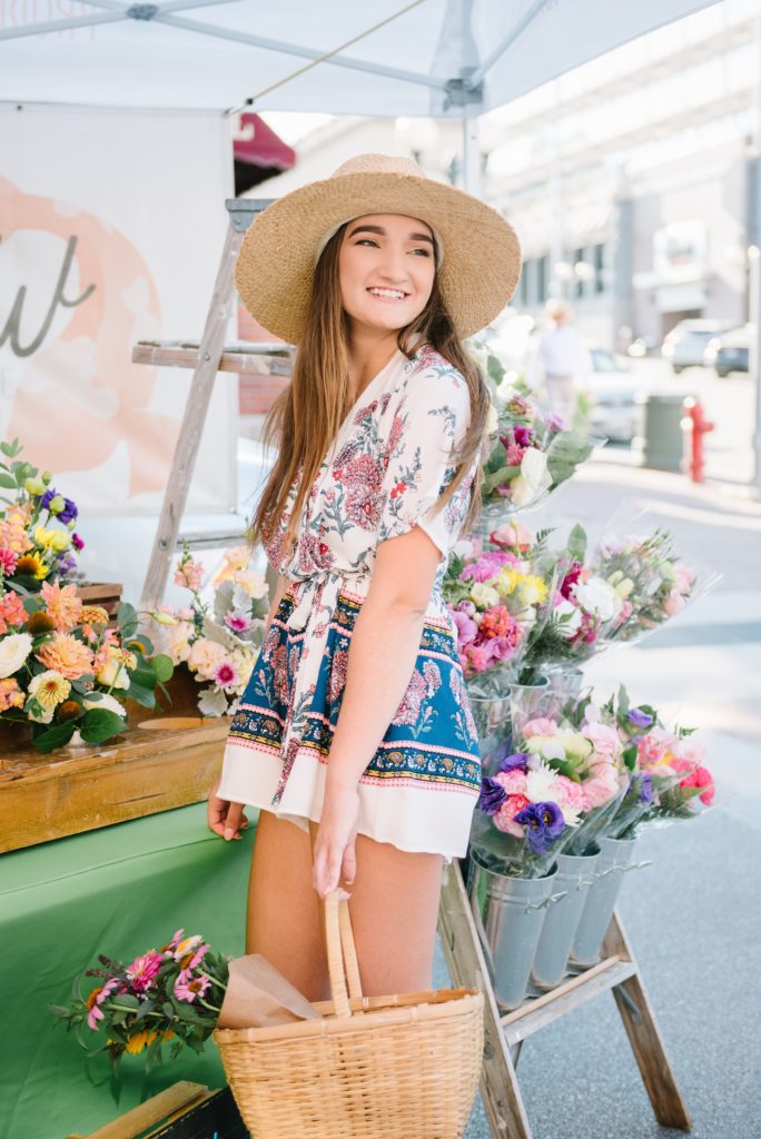 senior girl with hat and flowers in farmers market