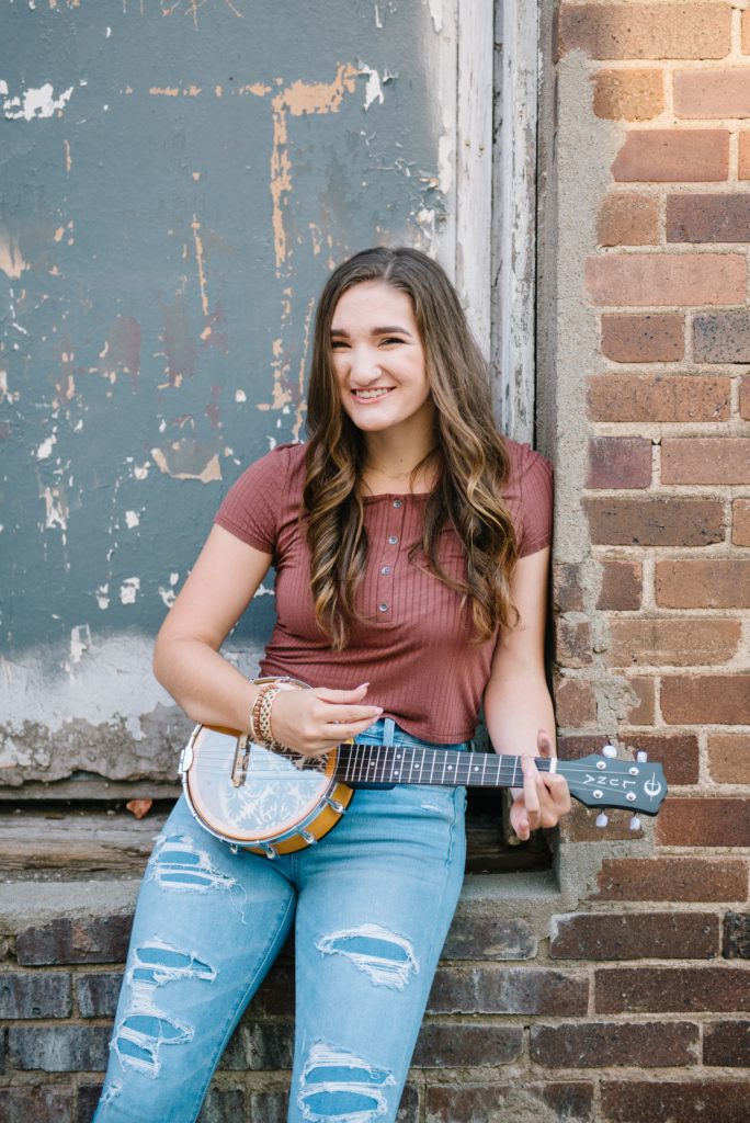 senior girl with ukulele in alley 